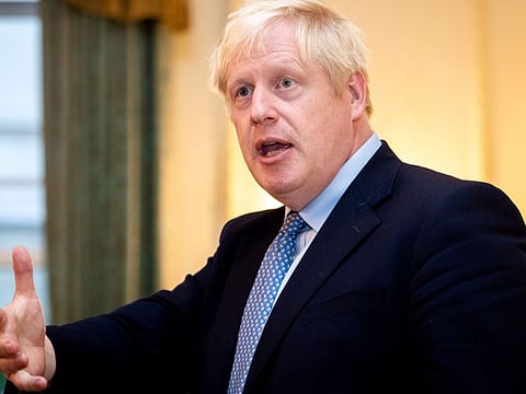 Britain's Prime Minister Boris Johnson gestures as he speaks to members of Britain's military during a reception for the Armed Forces inside 10 Downing Street in Central London on September 18, 2019.