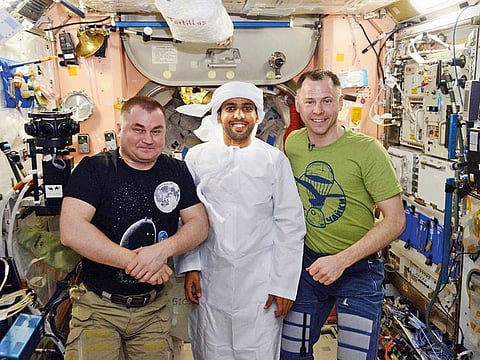 Hazzaa AlMansoori wears the kandoura as he shares a meal together with two of his colleagues on the ISS during the Emirati traditional night.