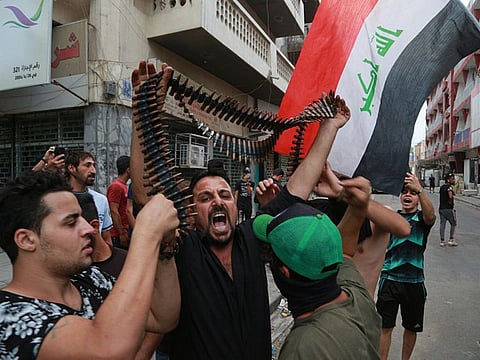 Protesters hold bullets belonging to Iraqi police during a protest in Baghdad, Iraq, Tuesday, Oct. 1, 2019. Iraqi security forces clashed with anti-government protesters in the capital and other provinces Tuesday, killing and injuring civilians, according to officials. (AP Photo/Hadi Mizban)