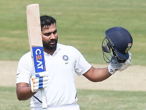 India's Rohit Sharma raises his bat after scoring a century during the first day's play of the first Test match against South Africa at the Dr. Y.S. Rajasekhara Reddy ACA-VDCA Cricket Stadium in Visakhapatnam on October 2, 2019.