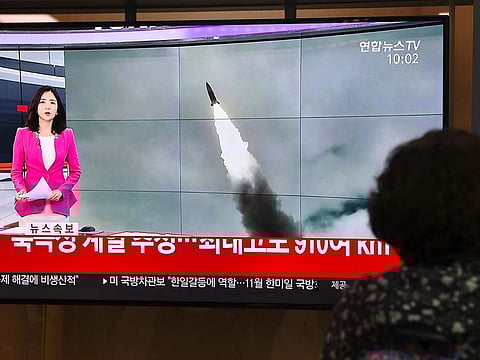 A woman watches a television news screen showing file footage of a North Korean missile launch, at a railway station in Seoul on October 2, 2019.