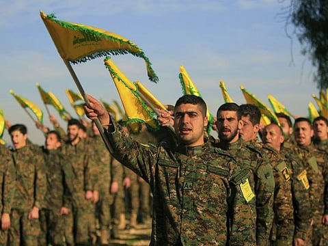 In this February 13, 2016 file photo, Hezbollah fighters hold flags as they attend the memorial of their slain leader Sheik Abbas al-Mousawi, who was killed by an Israeli airstrike in 1992, in Tefahta village, south Lebanon.