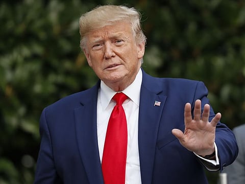 US president Donald Trump gestures towards members of the media on the South Lawn of the White House in Washington, Thursday, Oct. 3, 2019, after his return from Florida