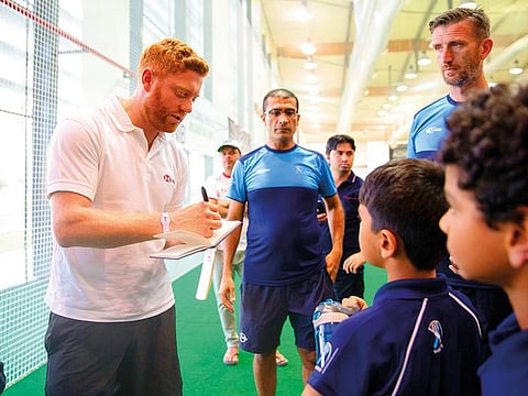 Jonny Bairstow signs autographs to young fans at the ICC Academy in Dubai.