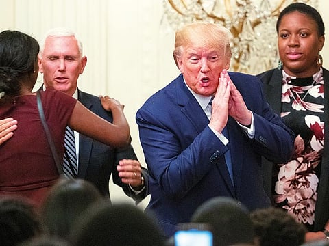 President Donald Trump gestures to the audience after a prayer on stage at the Young Black Leadership Summit 2019 in the East Room of the White House in Washington.