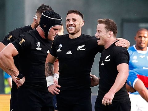 New Zealand's TJ Perenara celebrates with teammates scoring their 10th try against Namibia.