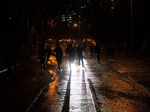 Protestors run away from police in Hong Kong, Sunday, Oct. 6, 2019.