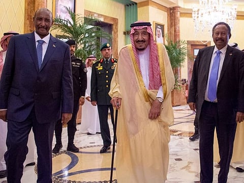 Al Burhan (L) and Hamdok (R) with Saudi King Salman (C).