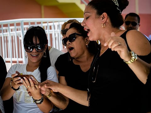 Fans sing while they wait in line outside of the Miami-Dade County Auditorium during a public funeral from the late singer Jose Jose in Miami, Florida on October 6, 2019. The artist born Jose Romulo Sosa Ortiz, who died last Saturday at age 71, is being honored at a funeral home southeast of Miami. / AFP / Eva Marie UZCATEGUI