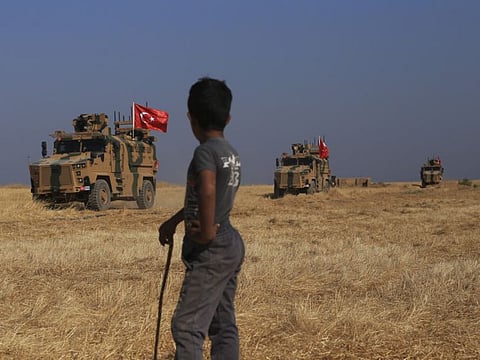 Turkish armoured vehicles patrol as they conduct a joint ground patrol with American forces in the so-called safe zone on the Syrian side of the border.
