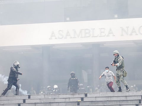 Riot police and a soldier are seen outside the National Assembly during protests against Ecuador's President Lenin Moreno's austerity measures, in Quito, Ecuador October 8, 2019.