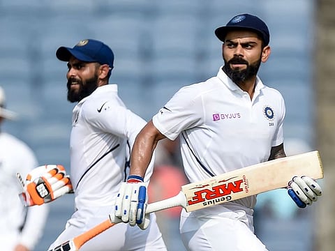 India's captain Virat Kohli (R) and Ravindra Jadeja run between the wickets on the second day of the second Test cricket match against South Africa at the Maharashtra Cricket Association Stadium in Pune on October 11, 2019.