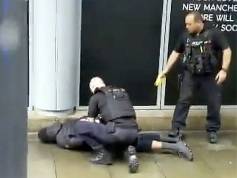 In this image taken from mobile phone footage, police arrest a man outside the Arndale Centre in Manchester, England, Friday October 11, 2019, after a stabbing incident at the shopping center that left four people injured.