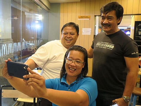 Sonny Parsons (R), leader of Filipino boyband Hagibis, poses for a photo with fans at a fastfood restaurant in Manila, Philippines.