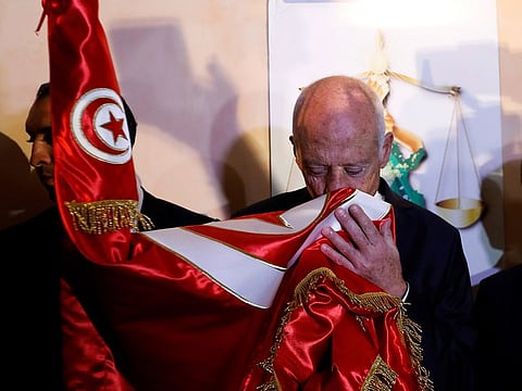 Tunisian presidential candidate Kais Saied and his wife Ichraf Chebil react after exit poll results were announced in a second round runoff of the presidential election in Tunis