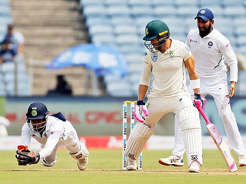 India's wicket keeper Wriddhiman Saha takes a catch of Faf du Plessis during fourth day of second cricket test match between India and South Africa in Pune, on October 13, 2019.