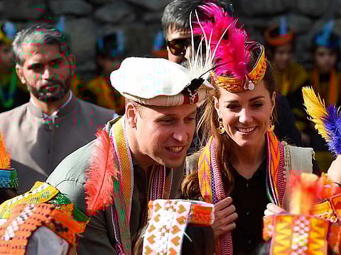 Britain's Prince William (C), Duke of Cambridge and his wife Catherine (R), Duchess of Cambridge, chat with members of the Kalash tribe during their visit to the Bumburate Valley in Pakistan northern Chitral District.