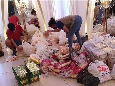 Volunteers gather food and water supplies for victims.