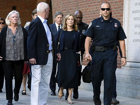 Felicity Huffman leaves federal court with her brother Moore Huffman Jr. following, after she was sentenced in a nationwide college admissions bribery scandal, Friday, Sept. 13, 2019, in Boston. (AP Photo/Michael Dwyer)