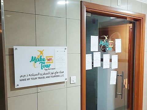 Notices from Abu Dhabi Department of Economic Development pasted on the door of Make My Tour’s office.