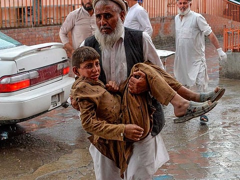 A volunteer carries an injured youth to hospital, following a bomb blast in Haska Mina district of Nangarhar Province on October 18, 2019.