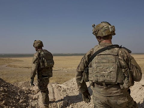 In this September 6, 2019 file photo, US soldiers survey the the safe zone between Syria and the Turkish border near Tal Abyad, Syria.