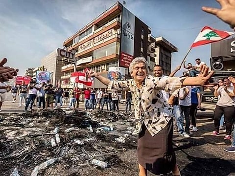 This elderly Lebanese woman is seen enjoying herself at a protest.