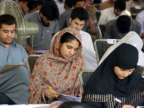 Students solve a question paper during an aptitude test of University of Engineering and Technology in Peshawar.