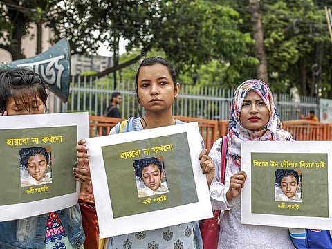 In this file photo taken on April 12, 2019 women hold placards with a photograph of schoolgirl Nusrat Jahan Rafi at a protest in Dhaka.