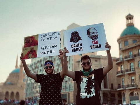 A protester holding up a picture of Gebran Bassil.