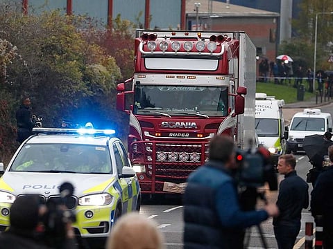 Police escort the truck that was found to contain a large number of dead bodies, as they move it from an industrial estate in Thurrock, south England, Wednesday Oct. 23, 2019.