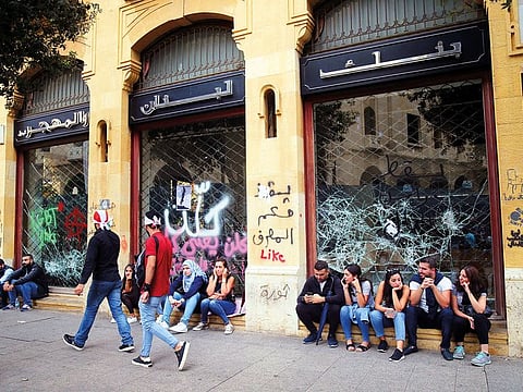 Protesters sit outside a Blom Bank branch in Beirut.