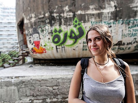 A woman attends an open-air lecture given by Jamil Mouawad (unseen), professor of political science at the American University of Beirut (AUB), at "the Egg" building in the centre of the Lebanese capital Beirut on October 24, 2019.