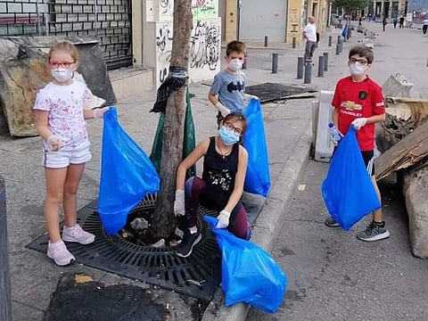 Young children seen picking up garbage after protests.