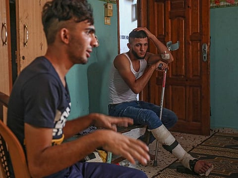 Mohammed Hellis (L) and his brother Ziad speak during an interview in their room in Gaza City's eastern suburb of Shejaiya on October 11, 2019. Mohammed, who has gained a dedicated group of young followers due to his reputation for bravery close to the fence, says people are "suffocated by life" in Gaza.