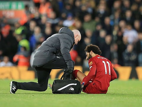 Liverpool's Mo Salah is treated for a knock against Tottenham Hotspur.