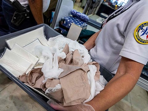 A Border Police officer carries drugs seized on a passenger, at the Felix Eboue Airport in Matoury, French Guiana, on January 27, 2019.