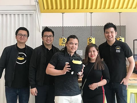 Irvin's Salted Egg founder and CEO Irvin Gunawan (extreme right), with customers and staff. He began selling flavored chips as a side dish to prop up a failing restaurant.