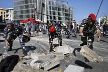 Lebanese policemen remove concrete set up by anti-government protesters to block a main road in Beirut on Wednesday.