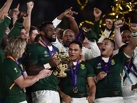South Africa's flanker Siya Kolisi (C) lifts the Webb Ellis Cup as they celebrate winning the Japan 2019 Rugby World Cup final match between England and South Africa at the International Stadium Yokohama in Yokohama on November 2, 2019.