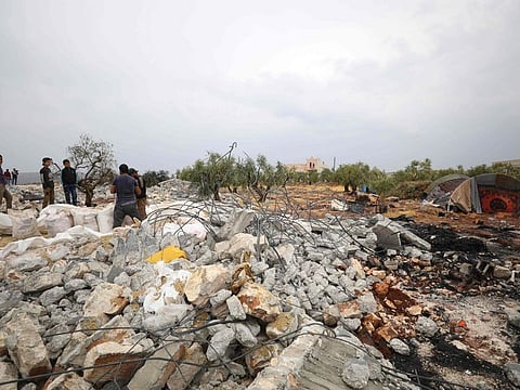 A picture taken on October 28, 2019 shows Syrians sifting through the rubble at the site of a suspected US-led operation against Islamic State (IS) chief Abu Bakr al-Baghdadi the previous day, on the edge of the small Syrian village of Barisha in the country's opposition-held northwestern Idlib province. US President Donald Trump announced that Baghdadi, the elusive leader of the jihadist group and the world's most wanted man, was killed in the early hours of Octobe 27 in an overnight US raid near the village, located less than five kilometres from Turkey and controlled by the dominant jihadist group Hayat Tahrir al-Sham, an organisation that includes former operatives from Al-Qaeda's Syria affiliate. / AFP / Omar HAJ KADOUR
