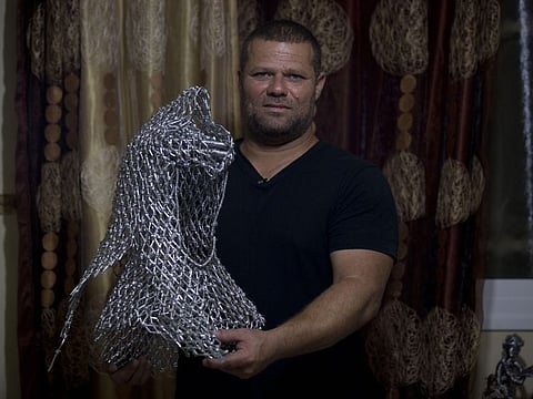 In this Saturday, Nov 2, 2019 photo, a Palestinian artist, Haitham Khatib, 43-year-old, displays metallic scenes a portrait of the late Palestinian leader, Yasser Arafat, with his famous keffiyeh, in the West Bank village of Bilin near Ramallah.