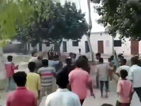 A teacher being thrashed by a group of students and their guardians