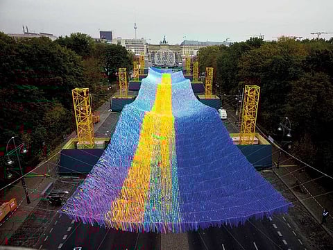 The Skynet artwork, Visions In Motion overhangs the Street of June 17 boulevard in front of the Brandenburg Gate in Berlin