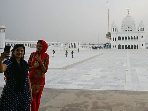 Sikh pilgrims take selfie pictures in front of the Shrine of Baba Guru Nanak Dev at the Gurdwara Darbar Sahib ahead of its opening, in the Pakistani town of Kartarpur near the Indian border.