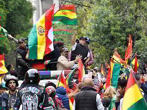 Luis Fernando Camacho, a Bolivian opposition leader, waves a Bolivian national flag in La Paz on November 10, 2019 after delivering a pre-written resignation letter at the Palacio Quemado (former Palace of Government) for Bolivia's President Evo Morales to sign.