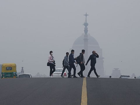 India's Presidential Palace seen covered in thick smog while tourists walking on the road, in New Delhi