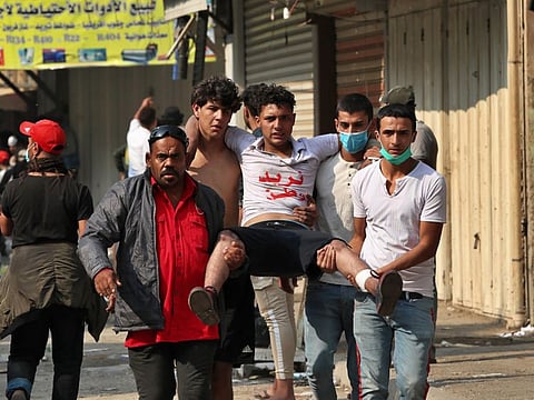 An injured protester is rushed to a hospital during clashes between Iraqi security forces and anti-government protesters in downtown Baghdad, Iraq, Tuesday, Nov. 12, 2019.