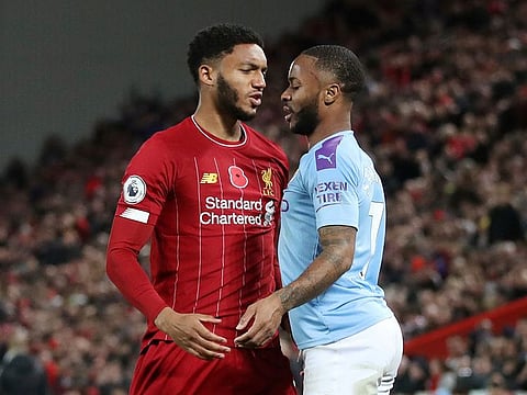 Manchester City's Raheem Sterling and Liverpool's Joe Gomez clash.