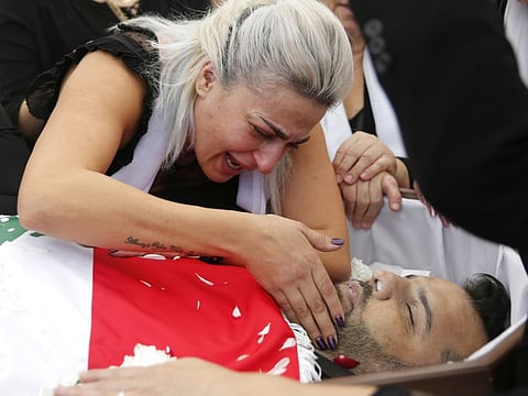 Lara, the wife of Alaa Abu Fakher, a man who killed by a Lebanese soldier on Tuesday night protests in southern of Beirut, mourns over her husband body during his funeral procession, in Choueifat neighborhood, Lebanon, Thursday, Nov. 14, 2019.